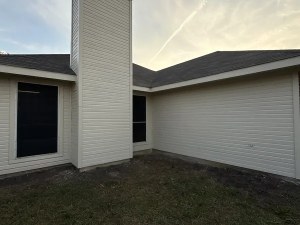 After: back of the house with new siding and trim and fresh exterior paint in Lancaster, TX