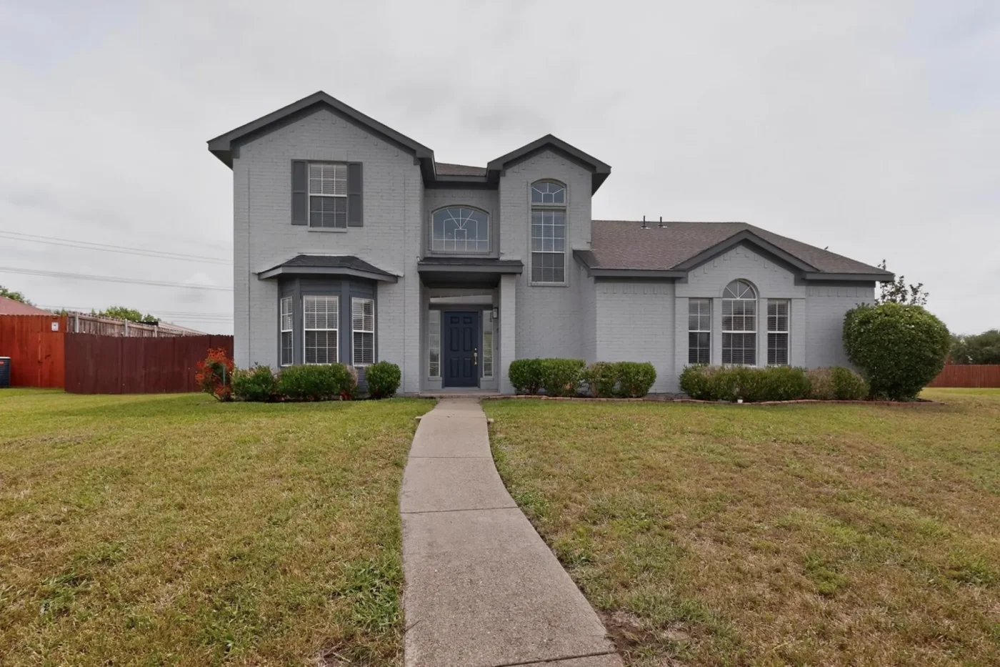 After: exterior renovation in DeSoto, TX, with painted brick and siding, a new roof and refreshed landscaping