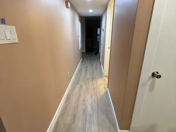 After: hallway with new vinyl plank flooring, baseboards and paint in Carrollton, TX
