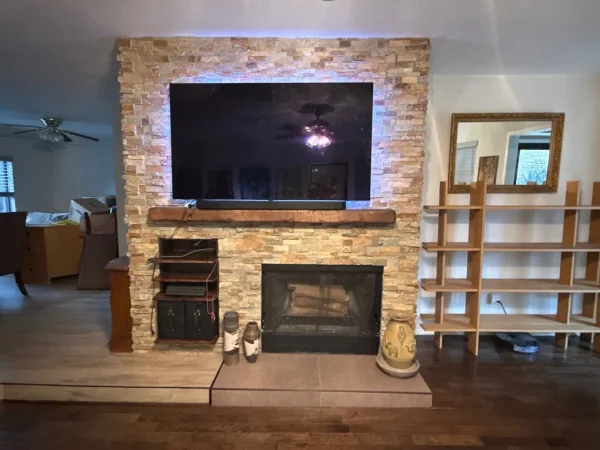 After: stacked stone fireplace, new hearth and vinyl plank flooring in the living room in Carrollton, TX