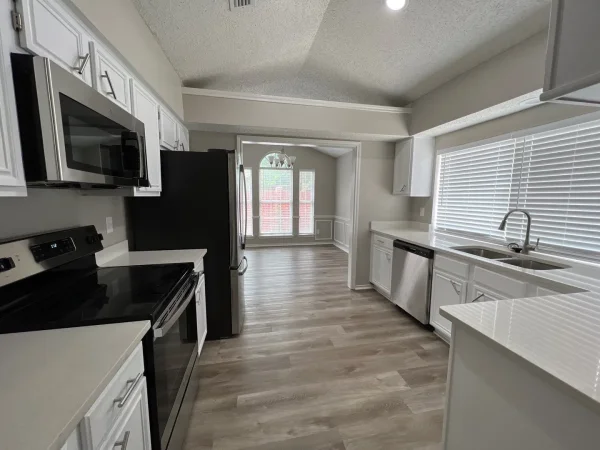 After: kitchen from the dining side with white cabinets and gray walls in Dallas, TX