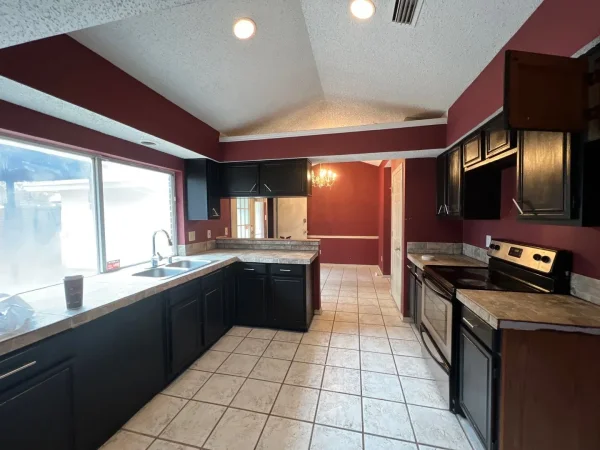 Before: kitchen with dark red walls and dark cabinets in Dallas, TX
