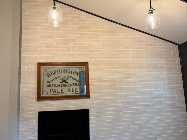 After: white fireplace brick wall with new pendant lights in Dallas, TX