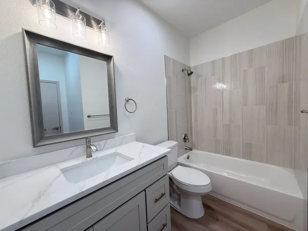 After: guest bathroom with new tub, tiled surround and new vanity in Dallas, TX