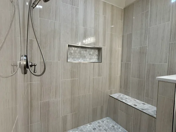 After: custom walk-in shower with niche, bench and mosaic floor, before the glass was installed, in Dallas, TX