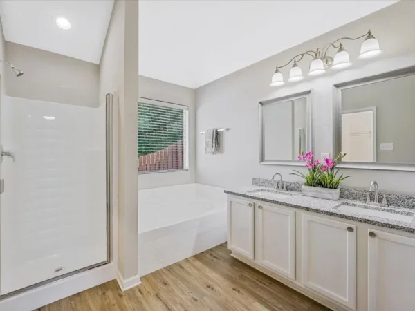 Before: primary bathroom with builder-grade shower, tub and double vanity in Dallas, TX