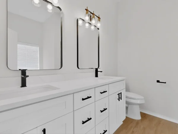 After: primary bathroom with a double vanity, framed mirrors and black fixtures in DeSoto, TX