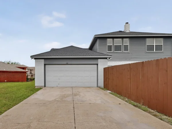 After: driveway and garage side with repaired fence in DeSoto, TX