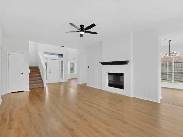After: living room with a painted fireplace and wood-look flooring in DeSoto, TX