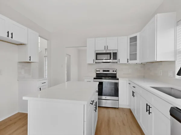 After: renovated kitchen with white cabinets and stainless appliances in DeSoto, TX